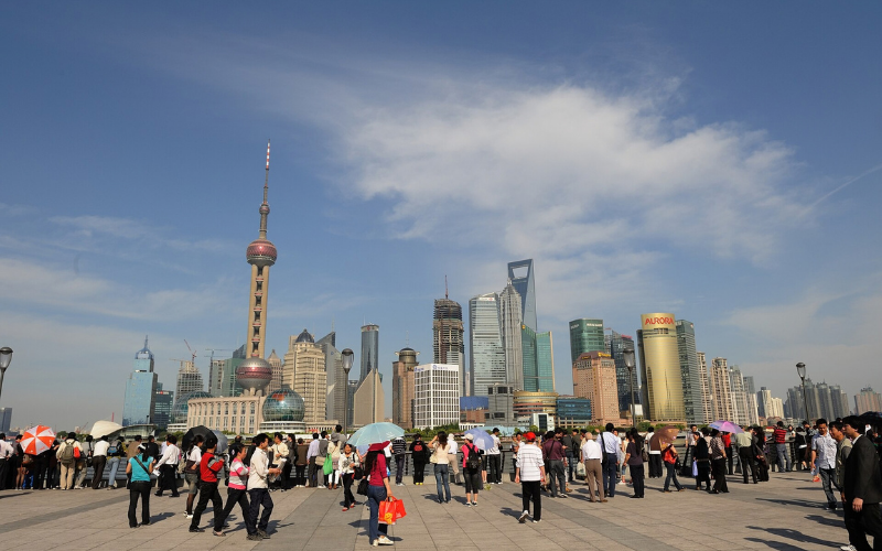 Turistas passeiam pelo Bund, em Xangai, com o skyline de Pudong ao fundo.